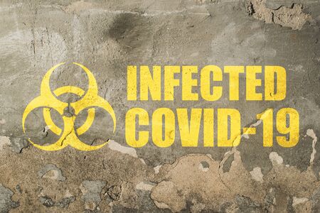 infected covid-19 sign, old grange plastered brick wall with written text, outbreak alert sign.の写真素材