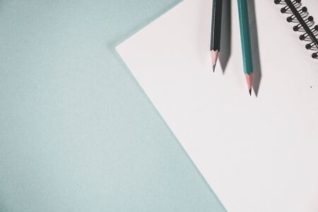 pencils and spiral notebook on a pastel light background. Notebook with blank clear page on the table.の写真素材