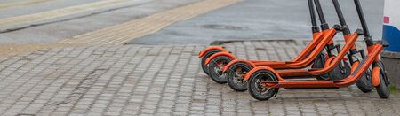 Electric kick scooters for rent in city. Urban modern alternative transportation and technology concept. Panoramic view.の写真素材