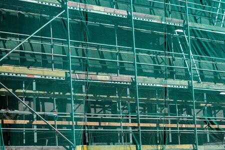 scaffolding covered in green mesh. Construction or repair work. perspective view.の写真素材