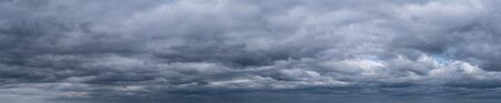 panorama of dramatic sky with clouds before a thunderstorm. Dark abstract background.の写真素材