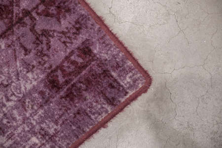 Gray fragment of floor with purple carpet as signpost as background