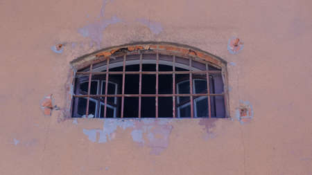 open wide prison window with rusty metal bars. Window in the wall.