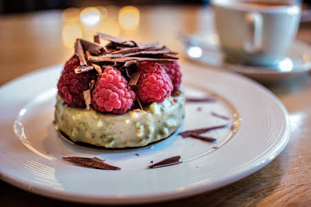 Cupcakes with fresh fruits and berries decorated with chocolate on a table in a cafe.