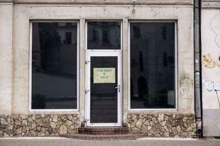 closed bankrupt store. Empty glass showcases. The sign on the door is for sale.