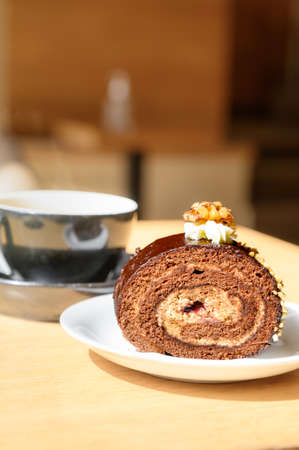 chocolate cake with ground nuts on top. Sweet swiss chocolate roll and coffee in cafe.の写真素材