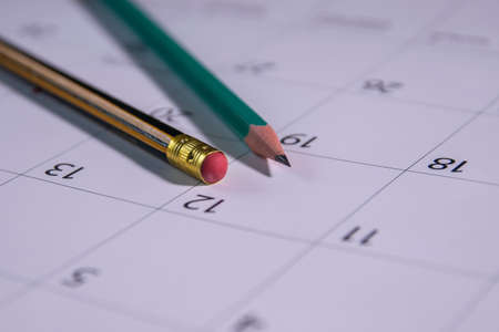 Close-up of two pencils on the date number on the calendar. rubber pencil.の写真素材