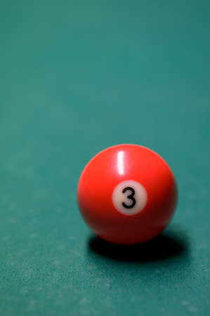 red billiard ball on a green billiard table close-up. snooker and billiards in the bar.