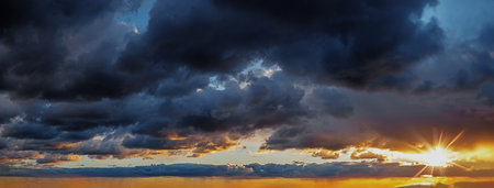 Evening golden sky over the sea at sunset. The sunset panorama is decorated with clouds of various...
