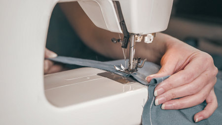 hands of an elderly woman sewing on a sewing machine. close-up.の写真素材