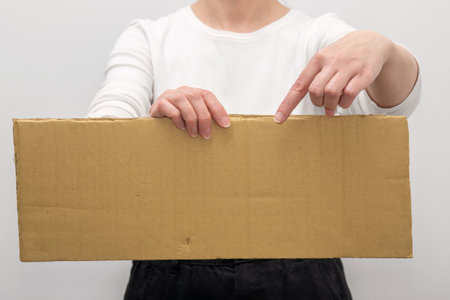 Woman in hands with a blank cardboard. mockup for agenda or activity information.の写真素材