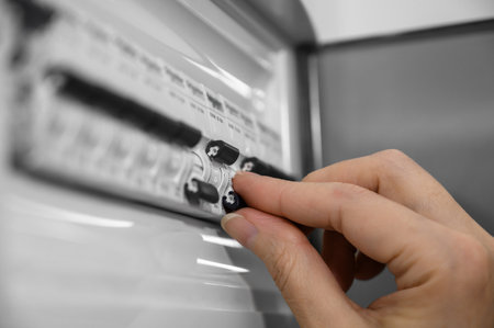 A woman turns off the light in the house in the electrical cabinet. Power, energy saving, energy saving.の写真素材
