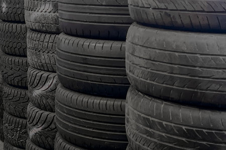 Tire stacks. Tires for sale in a tire store - stacks of old and new used tires.の写真素材