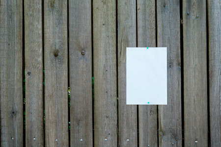 Blank white sheet of paper notice at the wooden fence. advertising mockup.の写真素材