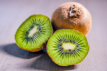 Two ripe kiwi fruit and half kiwifruit isolated on gray backgroundの写真素材