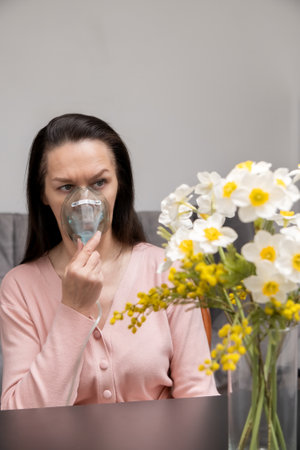 woman breathing through oxygen mask, allergic reaction to wildflowers. Medical equipment for inhalationの写真素材