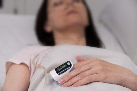 pulse oximeter on the finger close-up. patient in the hospital on a bed.の写真素材