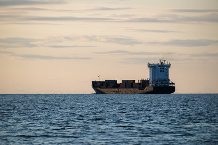 Container ship goes to sea against the background of the blue sky, Cargo transportation, Logistics import and export of goods.の写真素材