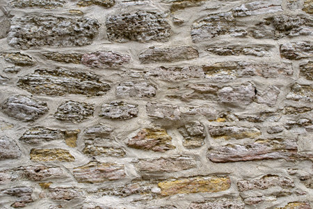 Pattern gray color design uneven cracked real stone wall surface with cementの写真素材