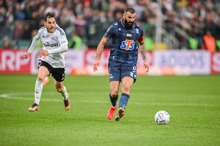 WARSAW, POLAND - APRIL 16, 2023: Polish Football League T-Mobile Ekstraklasa o/p: Yuri Ribeiro (Legia) Mikael Ishak (Lech)のeditorial素材