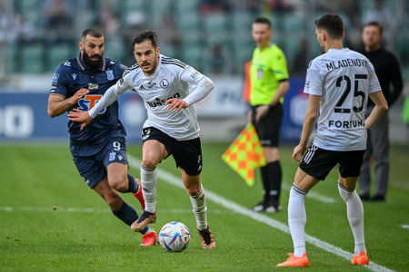 WARSAW, POLAND - APRIL 16, 2023: Polish Football League T-Mobile Ekstraklasa o/p: Mikael Ishak (Lech) Yuri Ribeiro (Legia)のeditorial素材