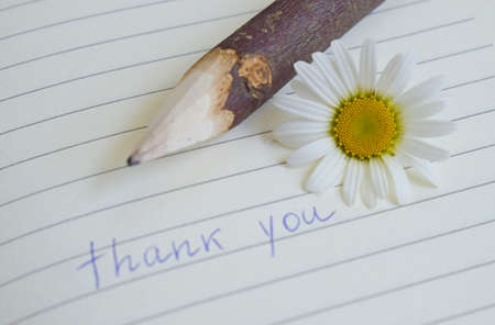 Thank you message and flower on notebook backgroundの写真素材