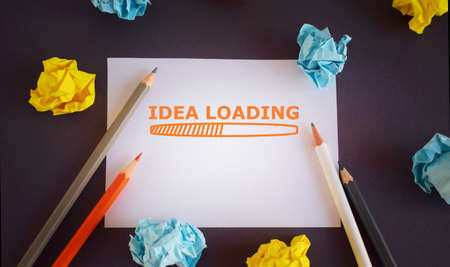 Handwriting text Idea Loading. Concept meaning Advertising the upcoming year Forecasting the future event. Pencils and paper lobs on dark backdropの写真素材