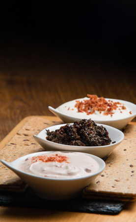 Three different sauces served on a wooden tableの写真素材