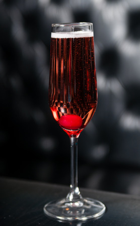 Glass of red sparkling wine served on a black table, ready for consumptionの写真素材