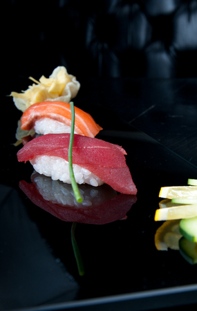 Decorated, two nigiri sushi served on a black plate.の写真素材