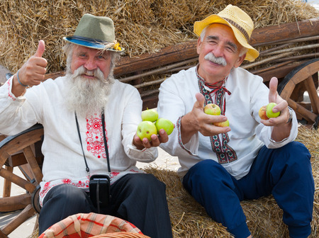MOSCOW - AUGUST 24: Senior men dressed in national costumes celebrating Apple Feast Day in Park VDNKH on August 24, 2014 in Moscow. Savior of Apple Feast Day is an Eastern Slavic folk holiday.のeditorial素材