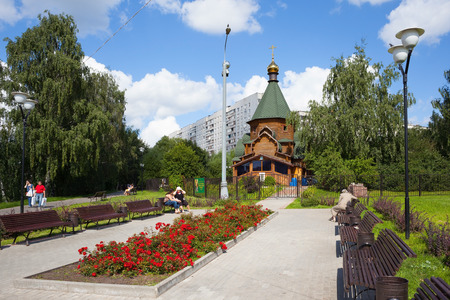 MOSCOW - AUGUST 2: People resting on benches near a wooden cathedral in Heritage Village Park in Bibirevo district on August 2, 2014 in Moscow. Bibirevo is administrative district of North-Eastern part of Moscow, Russia.のeditorial素材