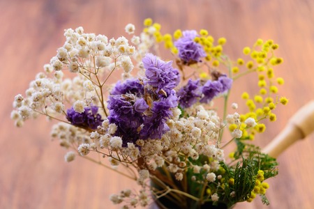 the macro dried-up flowers covered with dust in coffee the Turk on a wooden backgroundの写真素材