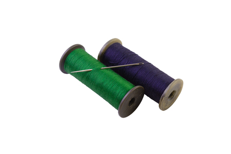 macro threads green and blue color on reels with an iron needle isolate on a white backgroundの写真素材