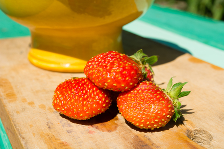Strawberry berries on a wooden board. Earlier morning in the summer in a garden.の写真素材