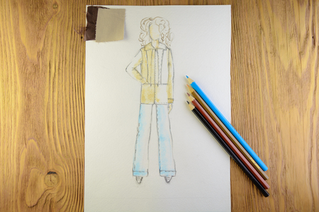 the drawing of designer clothes pencils on paper. background wooden table.の写真素材