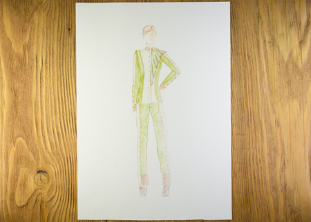 the drawing of designer clothes pencils on paper. background wooden table.の写真素材
