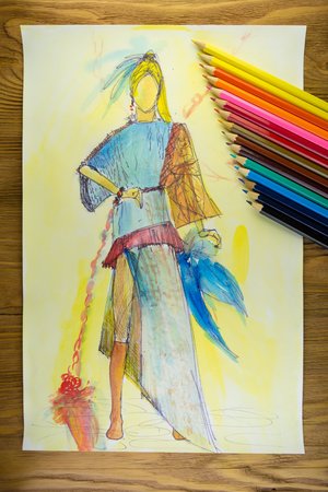 the drawing of designer clothes pencils on paper. background wooden table.の写真素材
