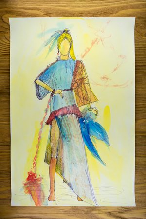 the drawing of designer clothes pencils on paper. background wooden table.