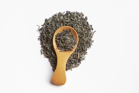 Dried tea leaves on a wooden spoon isolated over a wite background. top viewの写真素材