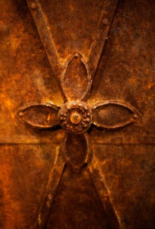 Old rusty metalwork with simple cross medallionの写真素材