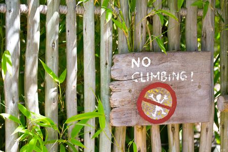 Rustic No Climbing Sign on a Wooden Fenceの写真素材