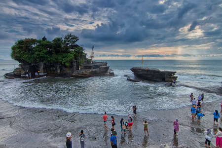 Ariel shot of a beach in Tanah Lot Bali where a crowd of tourist gathering at the beach and taking photos to preserve this memory with Tanah Lot main temple as backgroundのeditorial素材