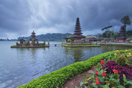 Nature shot of a beautiful garden by the side of the Bratan Lake with the floating tample as the background during bad weather dayの写真素材