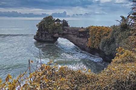 Great nature view of Pura Batu Bolong in a unique nature made cliff in Tanah Lot Bali with summer effectの写真素材
