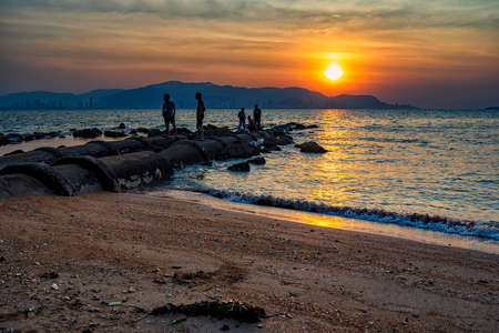 Penang,Malaysia-Mac 1st,2020:A group of man were seen enjoying sunset at the beach.Penang has beautiful sunset and sunrise in Malaysia.のeditorial素材