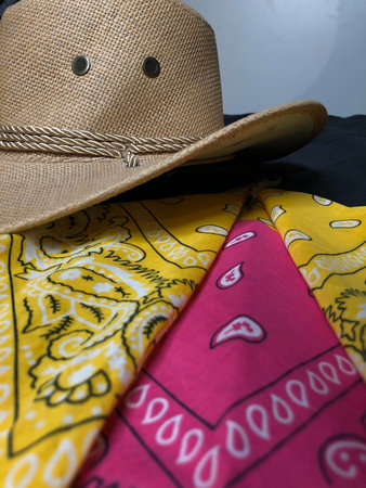 hat and colorful fabrics on a black background, closeup of photo