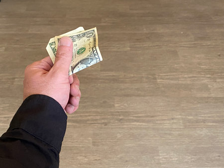 Hand holding dollar bills.