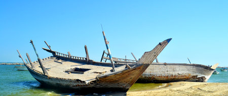 Wreck of old fishing boat on the shore of the sea.
