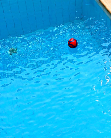 Swimming pool with red ball and blue water. Swimming pool background
